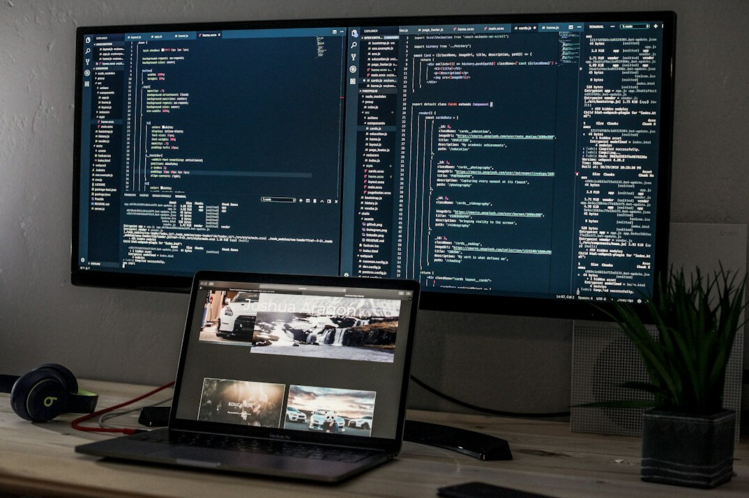 software developer coding on multiple screens